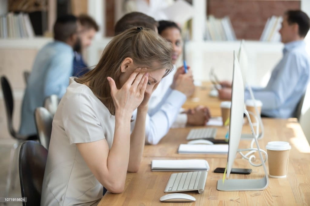 Employée de bureau fatiguée par des tensions posturales au travail